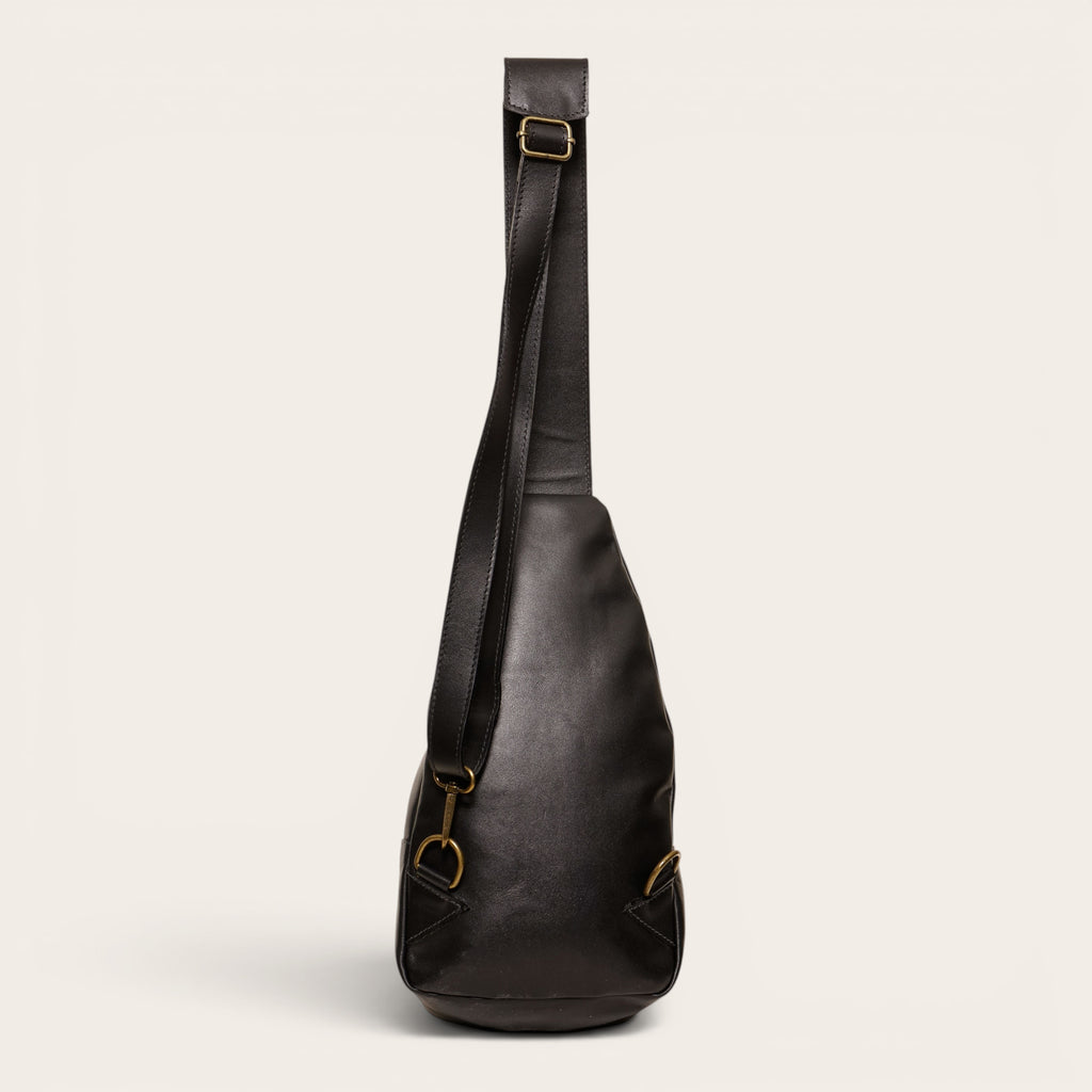 Bandolera Cunco Negro de cuero negro de OLKI con correa ajustable y herrajes envejecidos. Diseño ergonómico de 3.5 litros.