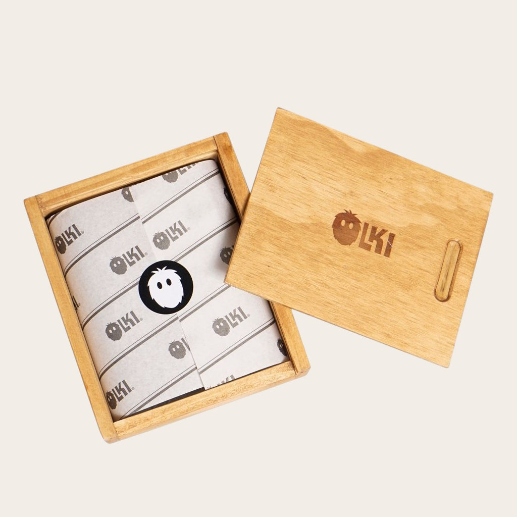 Billetera OLKI Ñuble verde musgo en cuero con acabado envejecido, presentada en caja de madera.