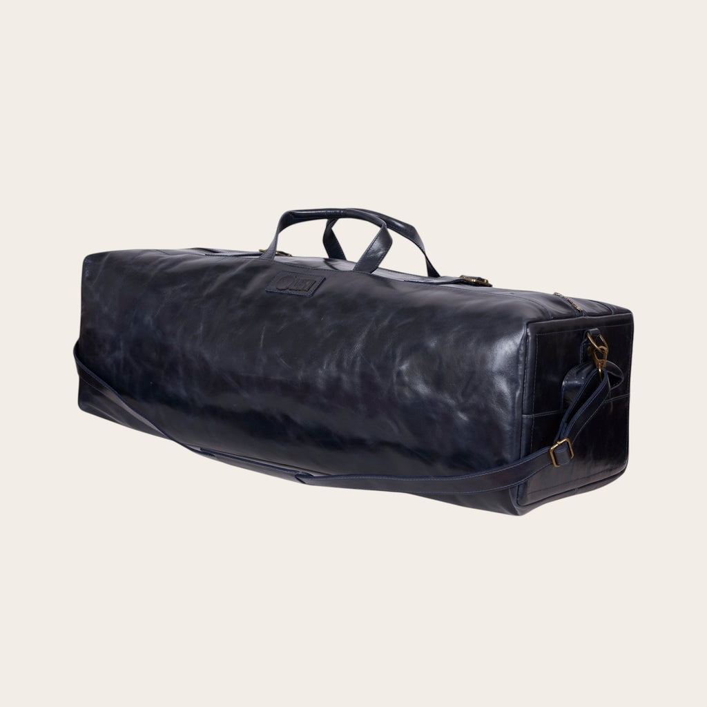Bolso de fin de semana OLKI de cuero azul marino con asas y correa de hombro ajustable.