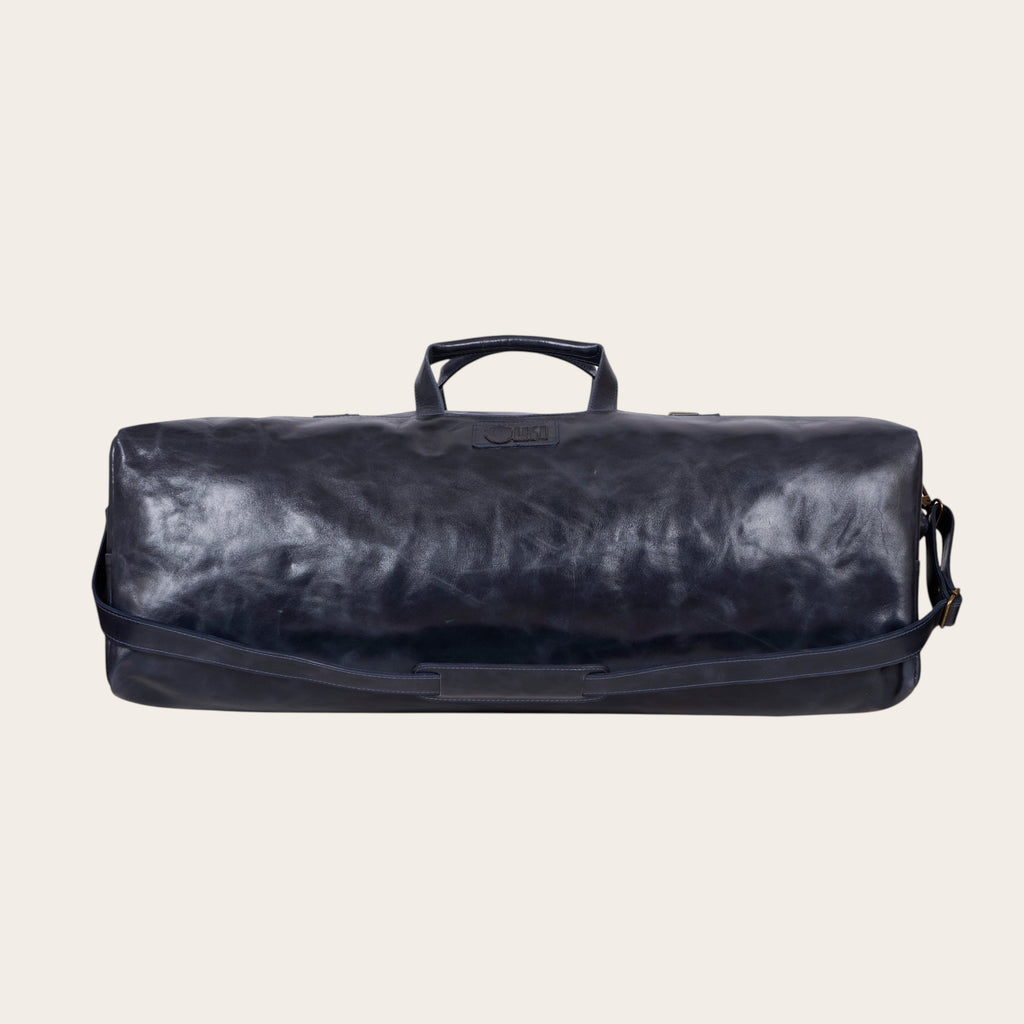 Bolso de fin de semana OLKI azul marino de cuero con asas y correa de hombro ajustable.
