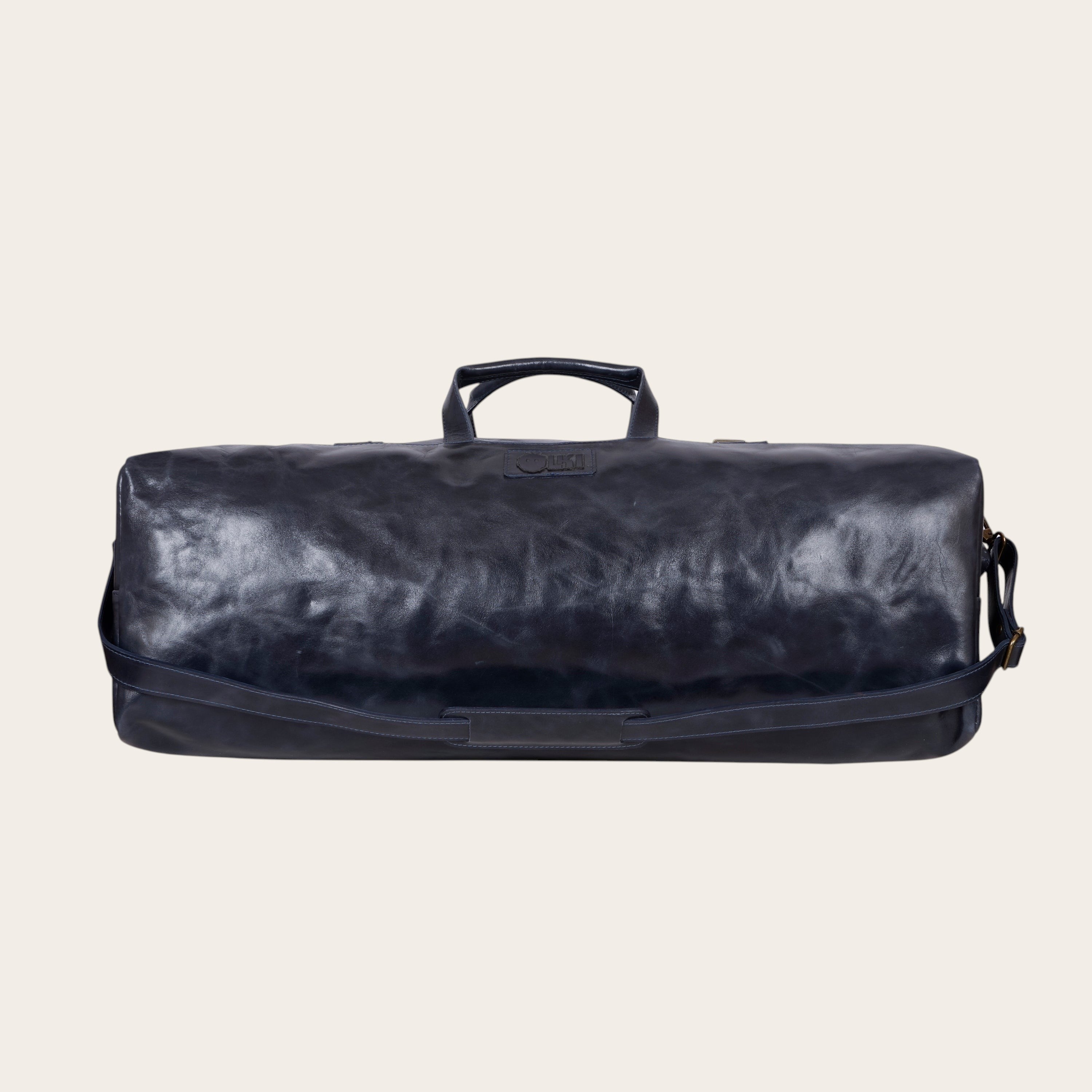 Bolso de fin de semana OLKI azul marino de cuero con asas y correa de hombro ajustable.