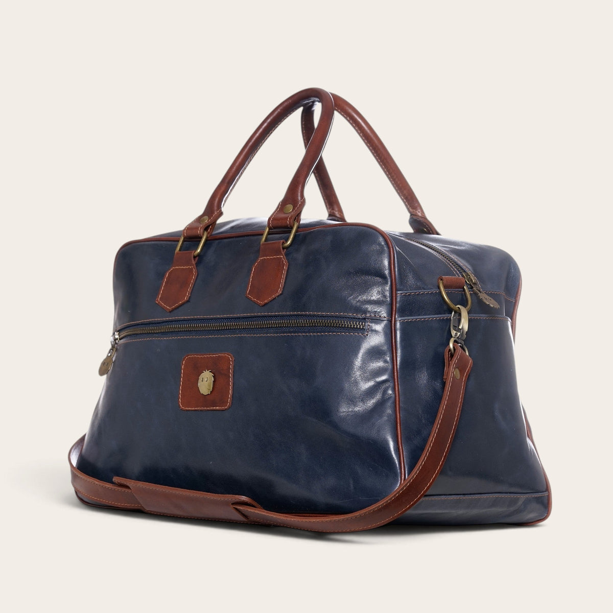 Bolso de viaje OLKI Rahue en cuero natural azul con detalles en cuero café, asas resistentes y correa ajustable.