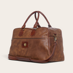 Bolso de viaje OLKI Rahue en cuero natural color café con asas de mano y correa ajustable para hombro