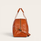 Bolso de viaje Baker Curry de cuero natural de vacuno de OLKI con asas y correa ajustable. Bolsillos interiores y exteriores, costuras reforzadas y herrajes envejecidos.