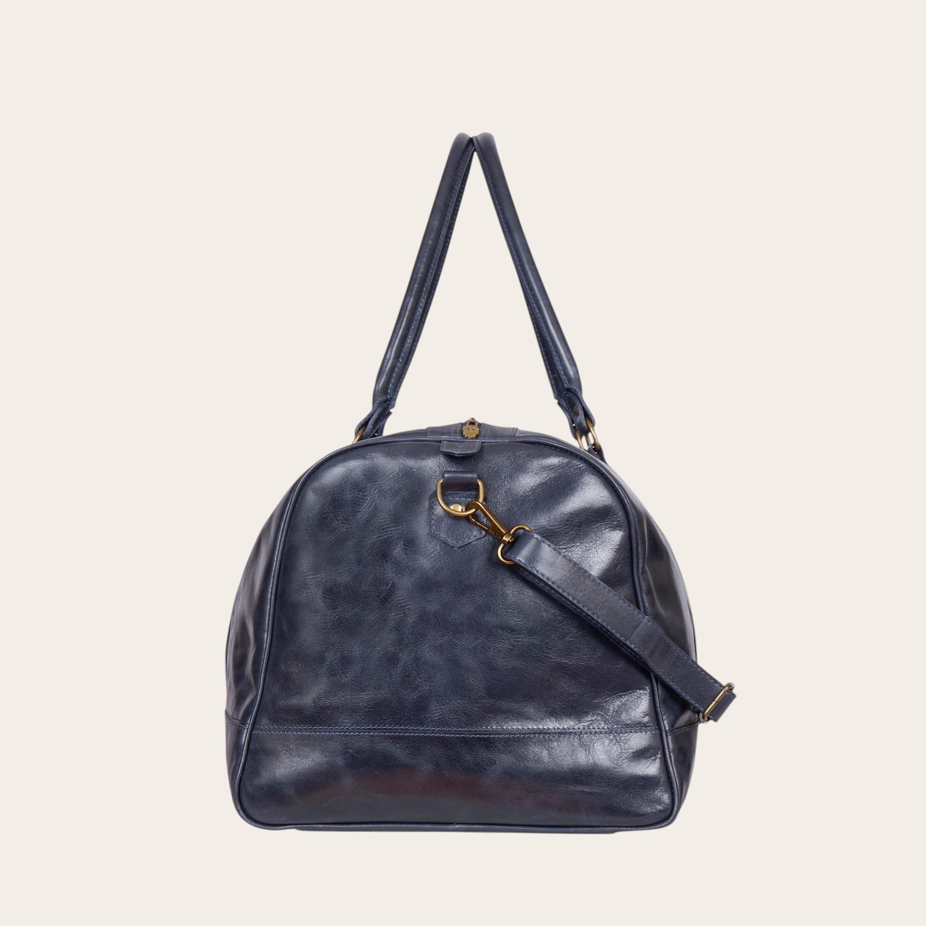 Bolso de viaje OLKI Futaleufu azul marino de cuero con acabado desgastado, asas superiores y correa de hombro.