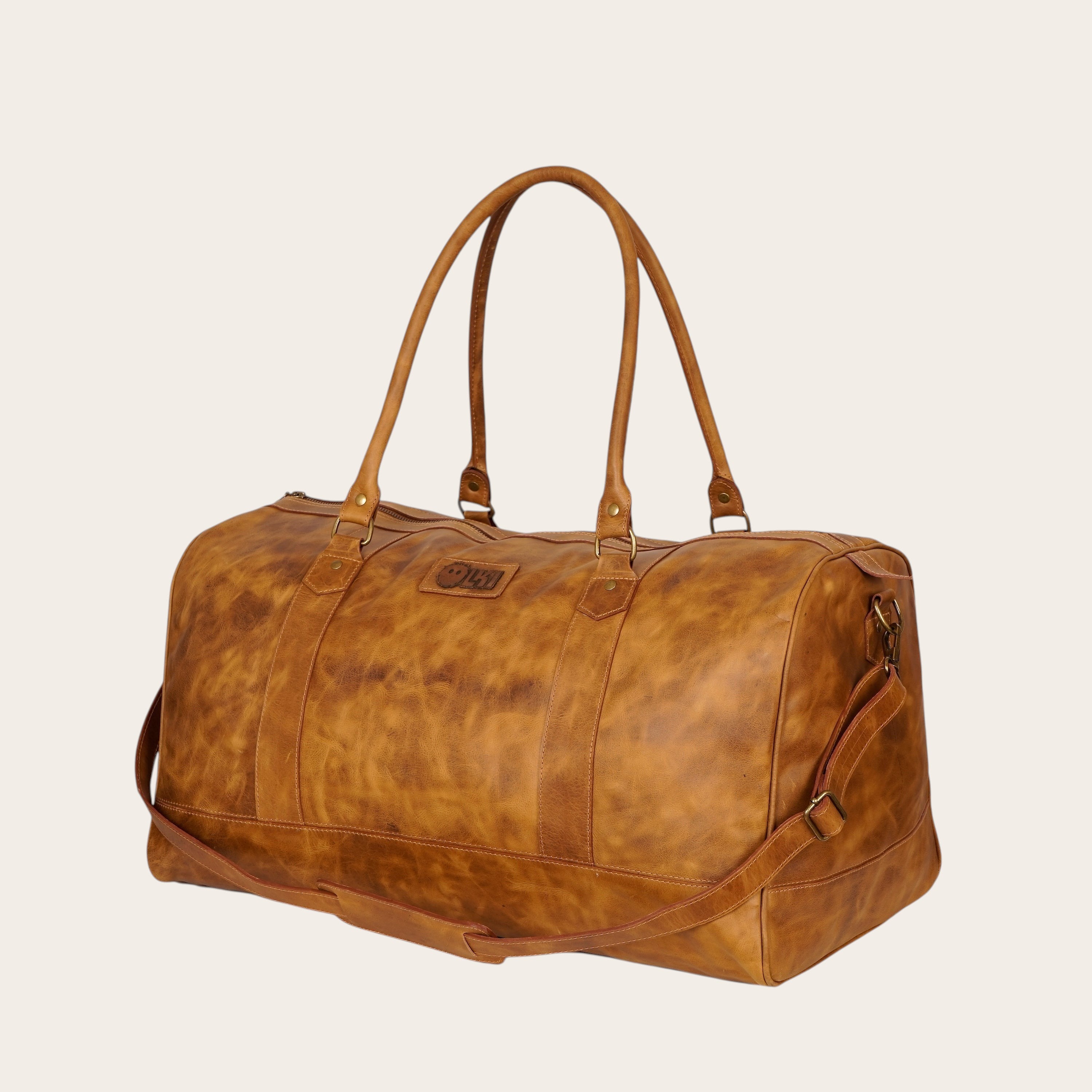 Bolso de viaje OLKI Futaleufu en cuero color caramelo con acabado envejecido, asas y correa ajustable. Ideal para escapadas.