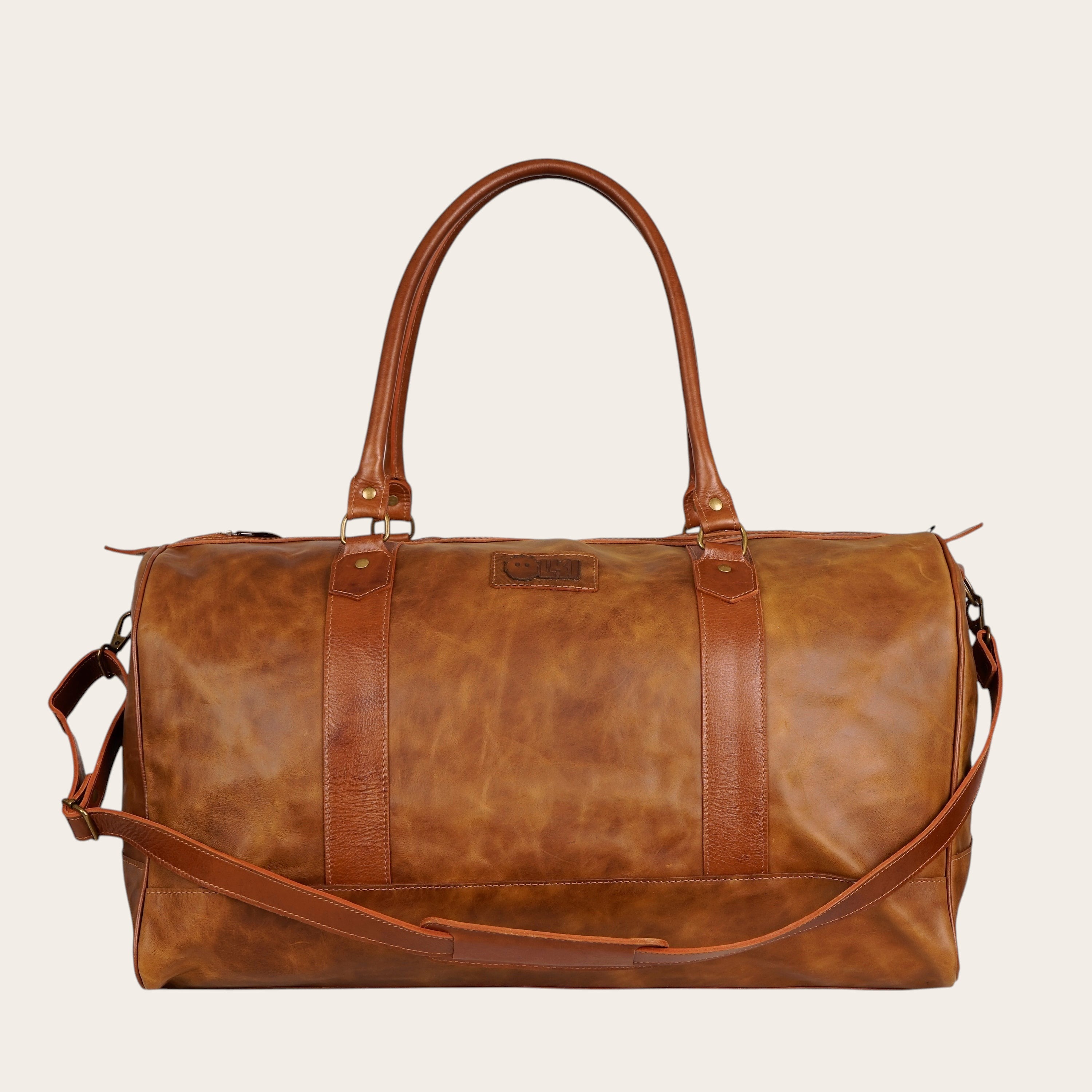 Bolso de viaje OLKI Futaleufu Carmelo Combinado de cuero genuino en tono caramel con detalles en cuero oscuro.