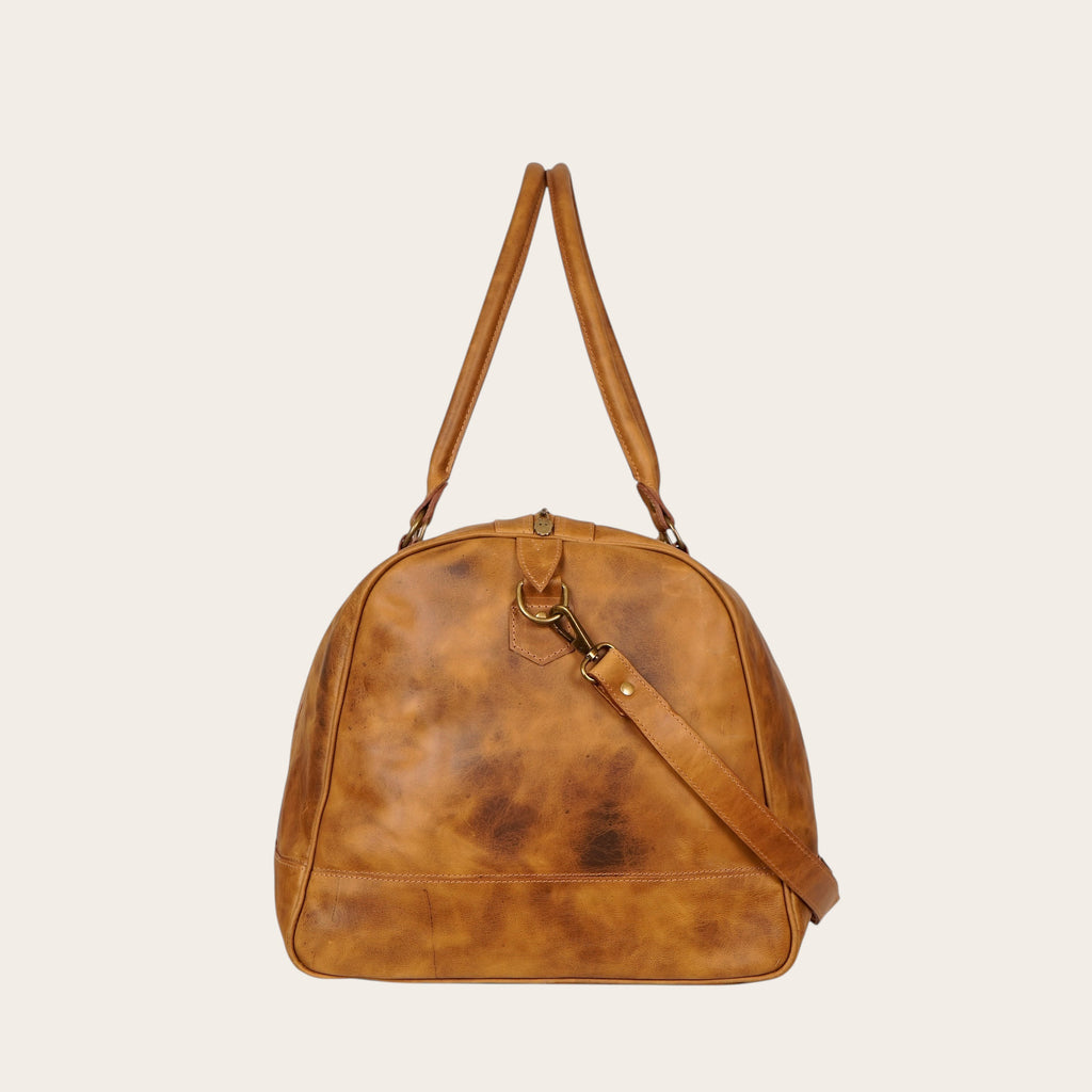 Bolso de viaje OLKI Futaleufu de cuero color caramelo con acabado envejecido y correa ajustable.
