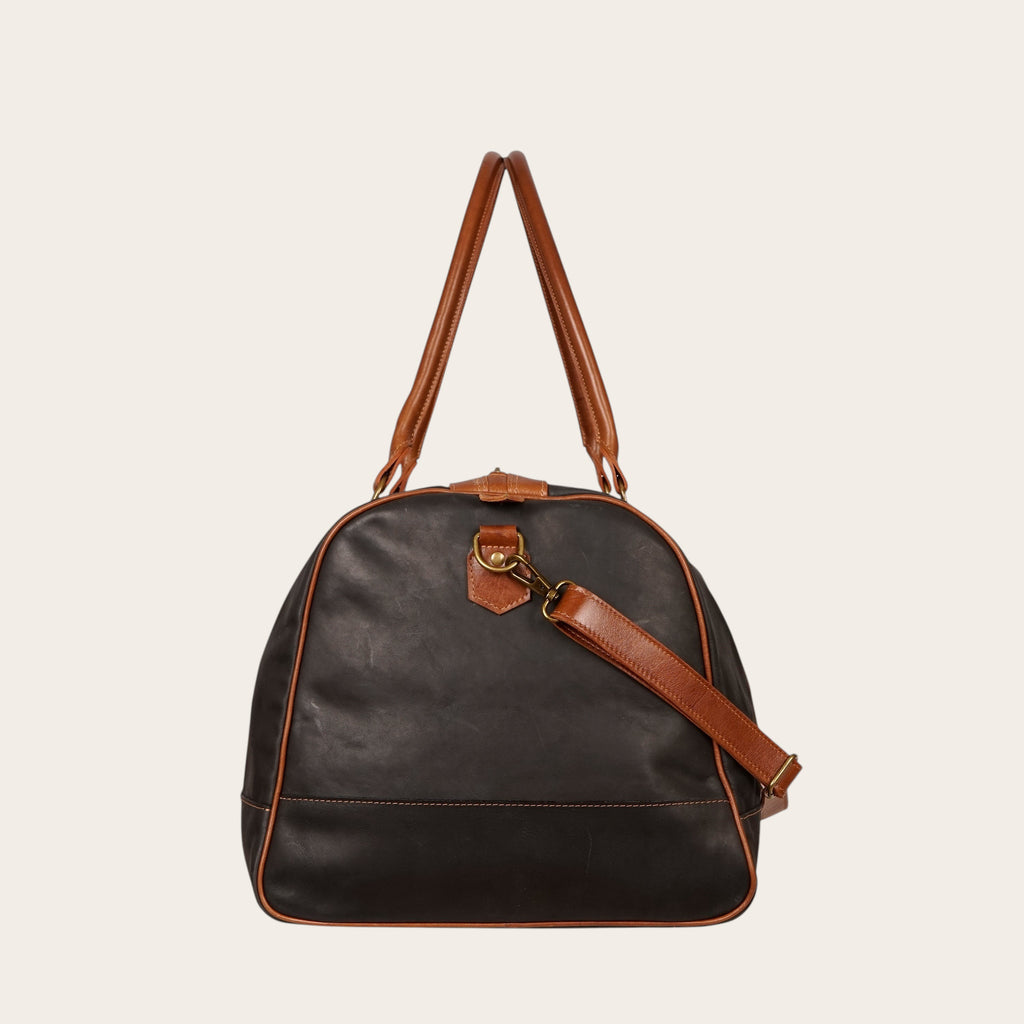 Bolso de viaje OLKI negro de cuero de vacuno con detalles en cuero marrón y herrajes envejecidos.