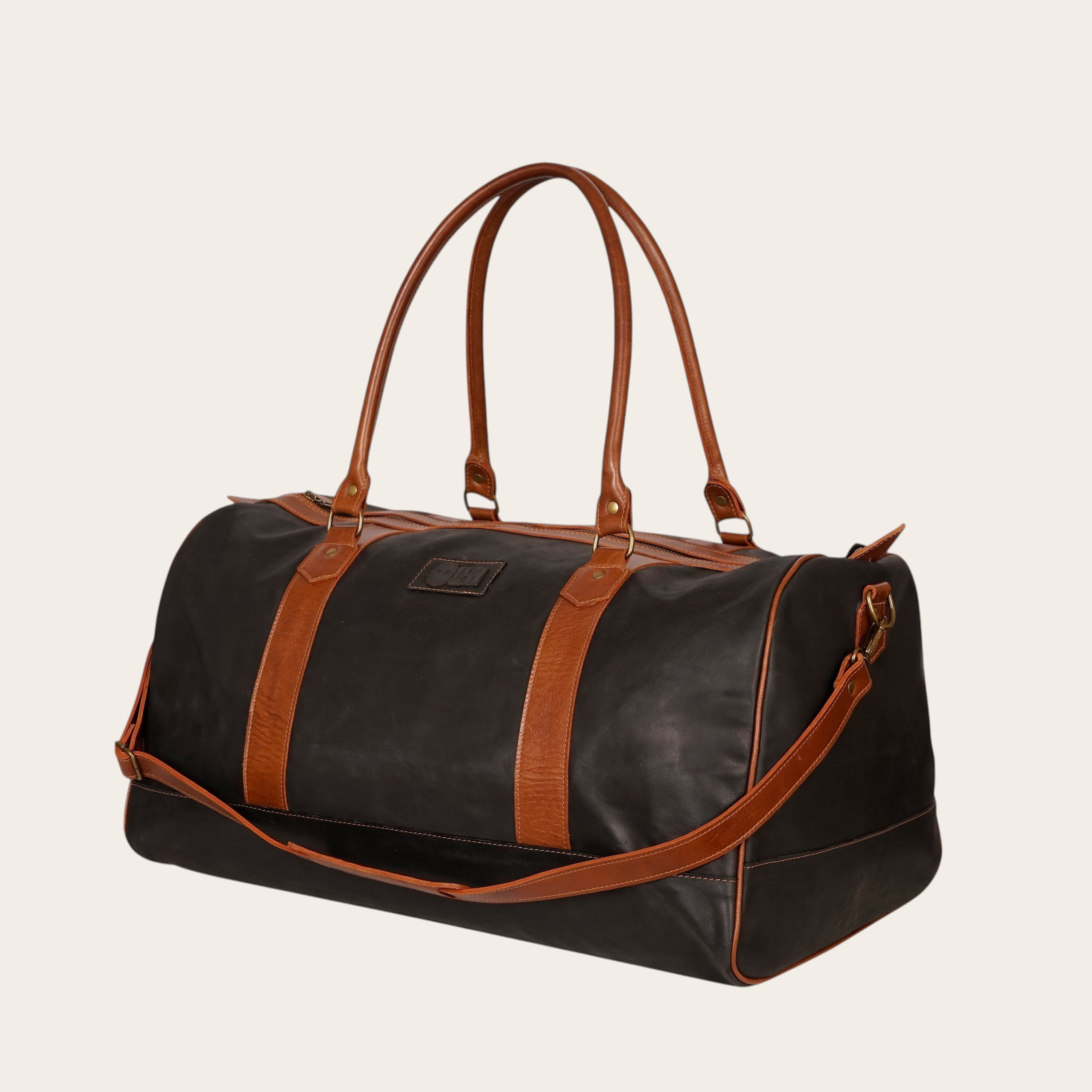 Bolso de viaje OLKI Futaleufu negro de cuero de vacuno con detalles en cuero marrón y herrajes envejecidos.
