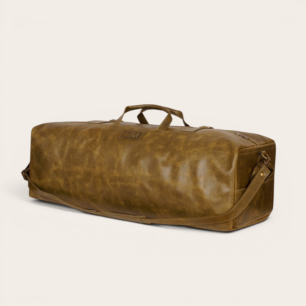 Bolso de viaje OLKI Yelcho en piel verde musgo con acabado envejecido, asas de mano y correa ajustable.