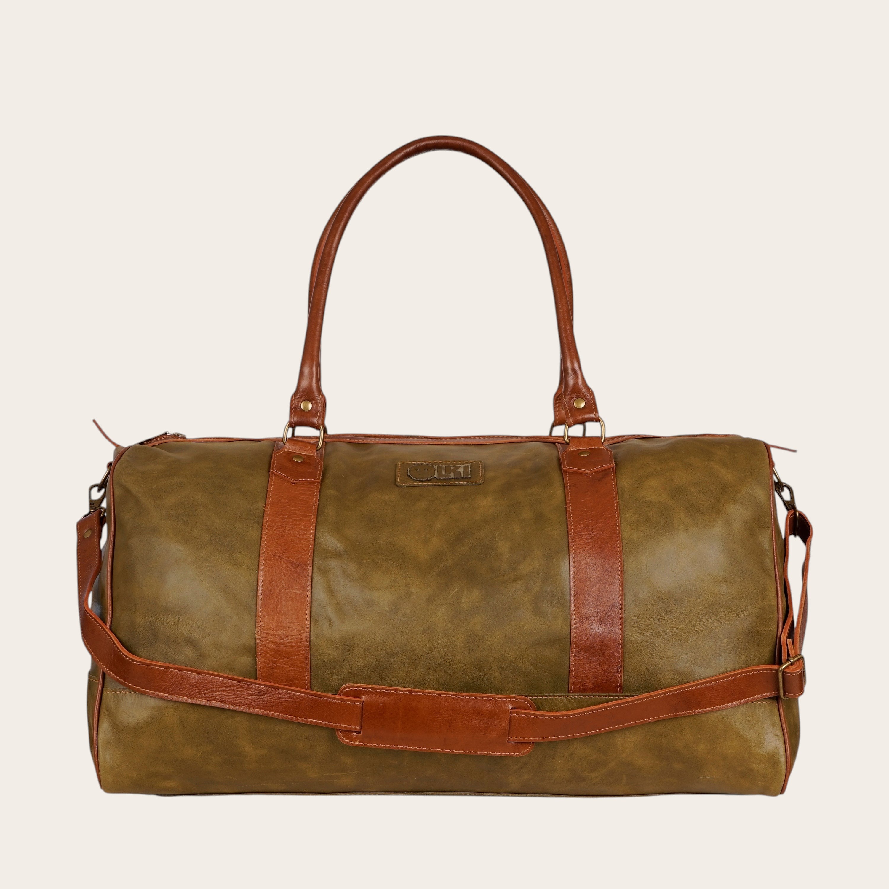 Bolso de viaje OLKI Futaleufu verde musgo en cuero natural con detalles marrón castaño, asas y correa ajustable.