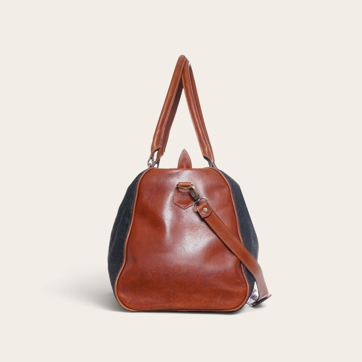 Bolso de viaje OLKI Futaleufú gris de mezclilla con detalles en cuero marrón y correa ajustable