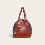 Bolso de viaje OLKI Futaleufú de mezclilla azul con detalles de cuero marrón y correa ajustable para hombro