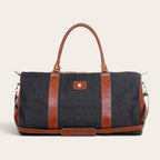 Bolso de viaje OLKI Futaleufú gris de mezclilla con detalles en cuero marrón y correa ajustable para fin de semana