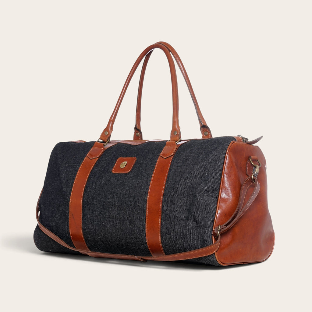 Bolso de viaje OLKI Futaleufú gris de mezclilla con detalles en cuero marrón, ideal para escapadas de fin de semana.