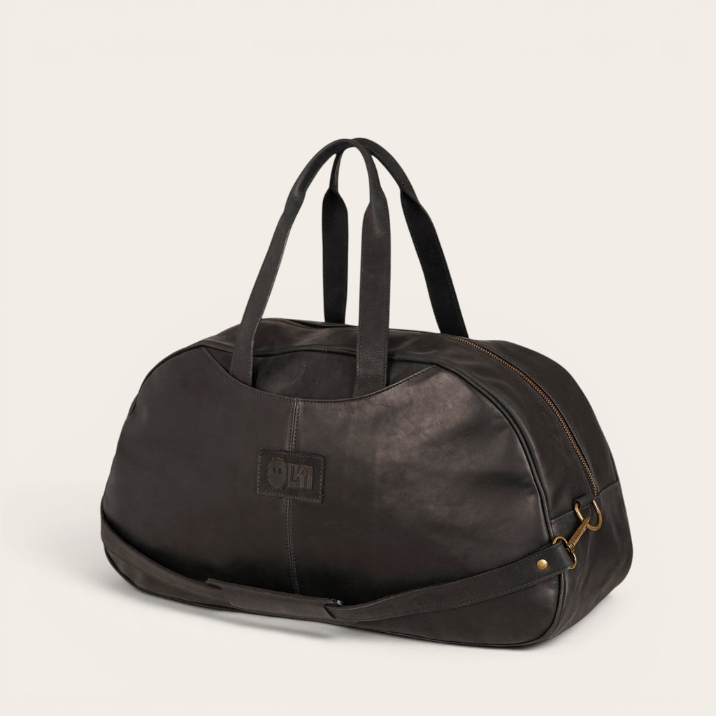 Bolso de viaje Baker negro de cuero de OLKI con asas superiores y correa de hombro desmontable.