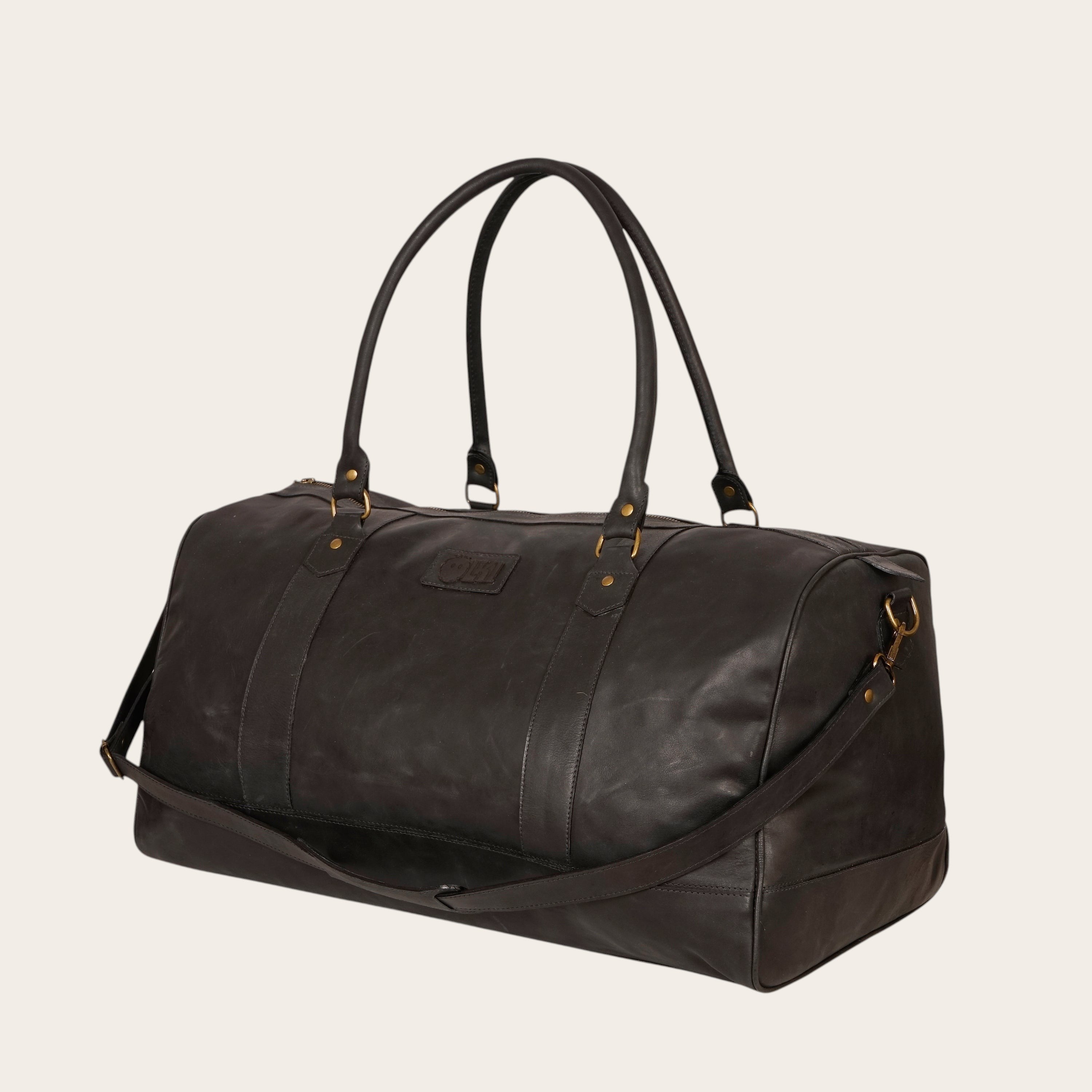 Bolso de viaje OLKI Futaleufu negro de cuero con asas superiores y correa de hombro ajustable. Ideal para escapadas de fin de semana.
