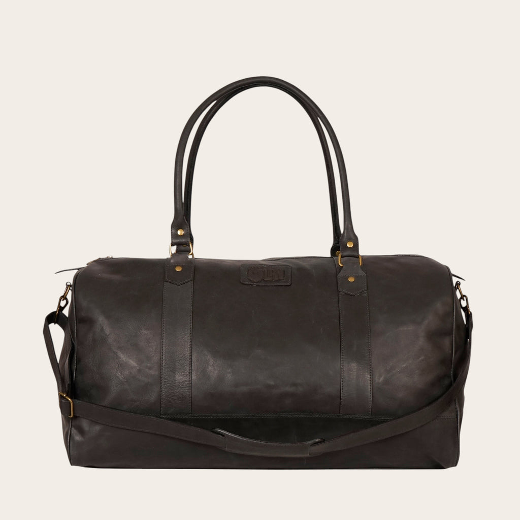 Bolso de viaje OLKI Futaleufú negro de cuero, espacioso, con asas superiores y correa de hombro ajustable. Ideal para escapadas.