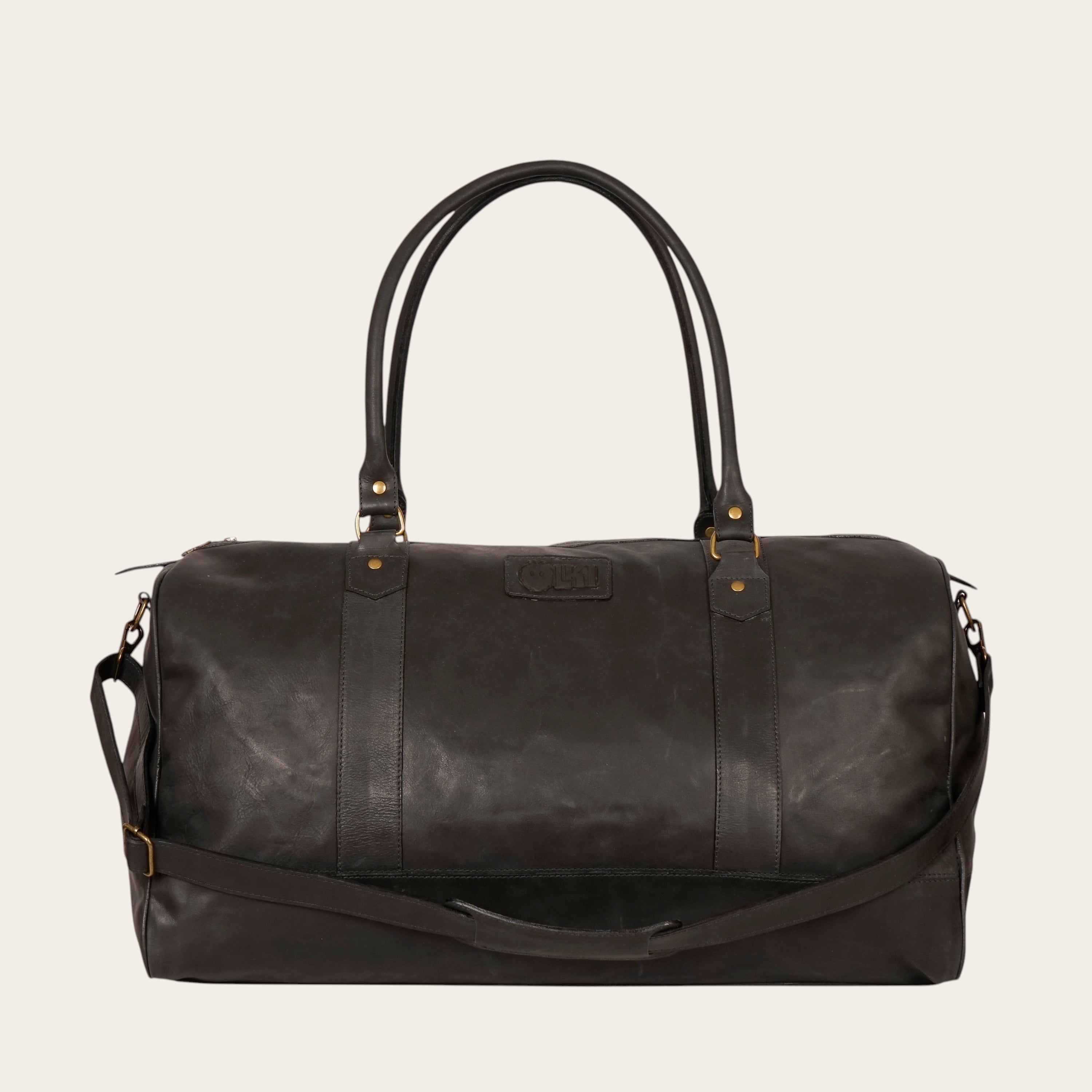 Bolso de viaje OLKI Futaleufú negro de cuero, espacioso, con asas superiores y correa de hombro ajustable. Ideal para escapadas.