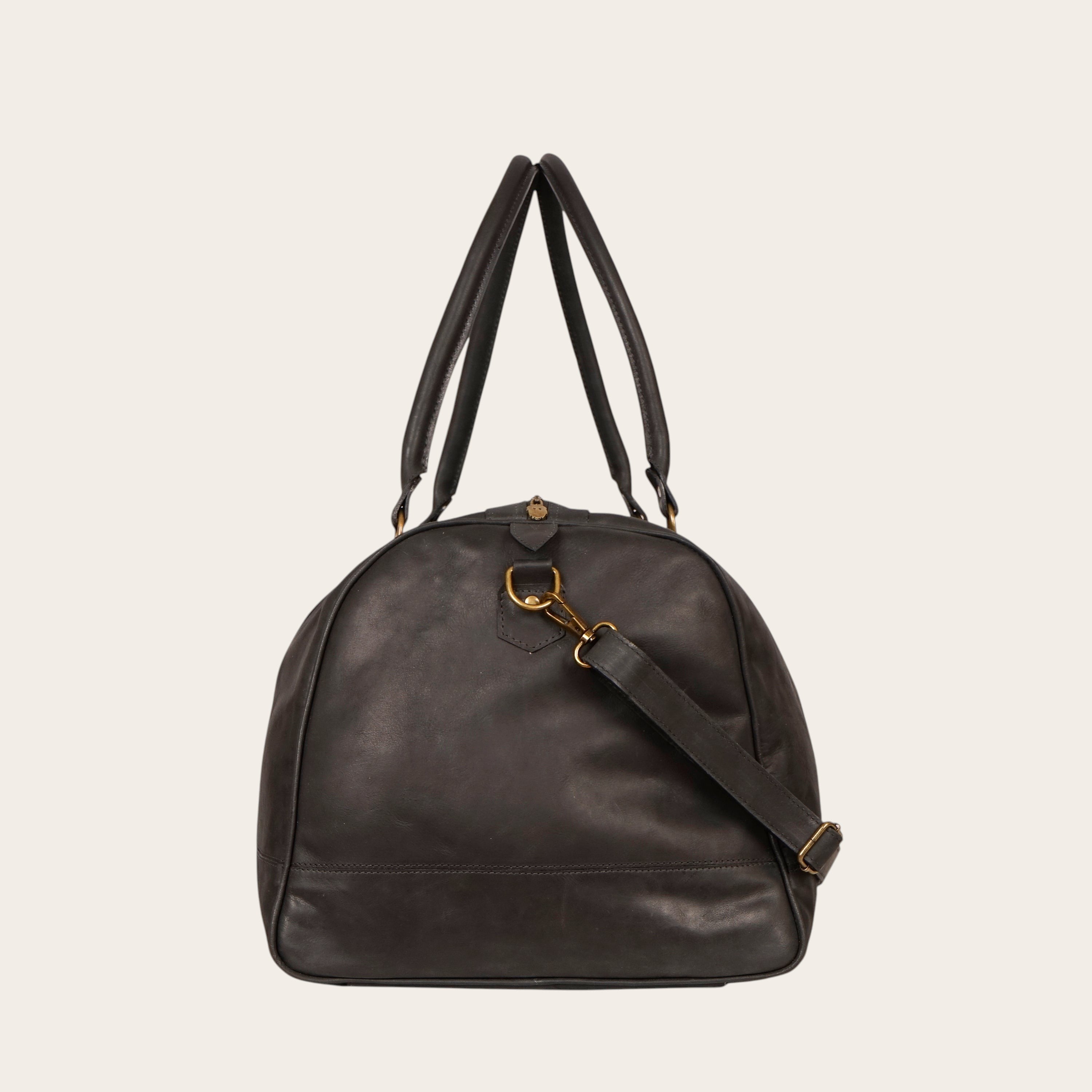 Bolso de viaje OLKI Futaleufu negro de cuero con asas superiores y correa de hombro ajustable.
