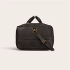 Bolso de viaje OLKI Yelcho negro de piel con asas superiores y correa de hombro extraíble.