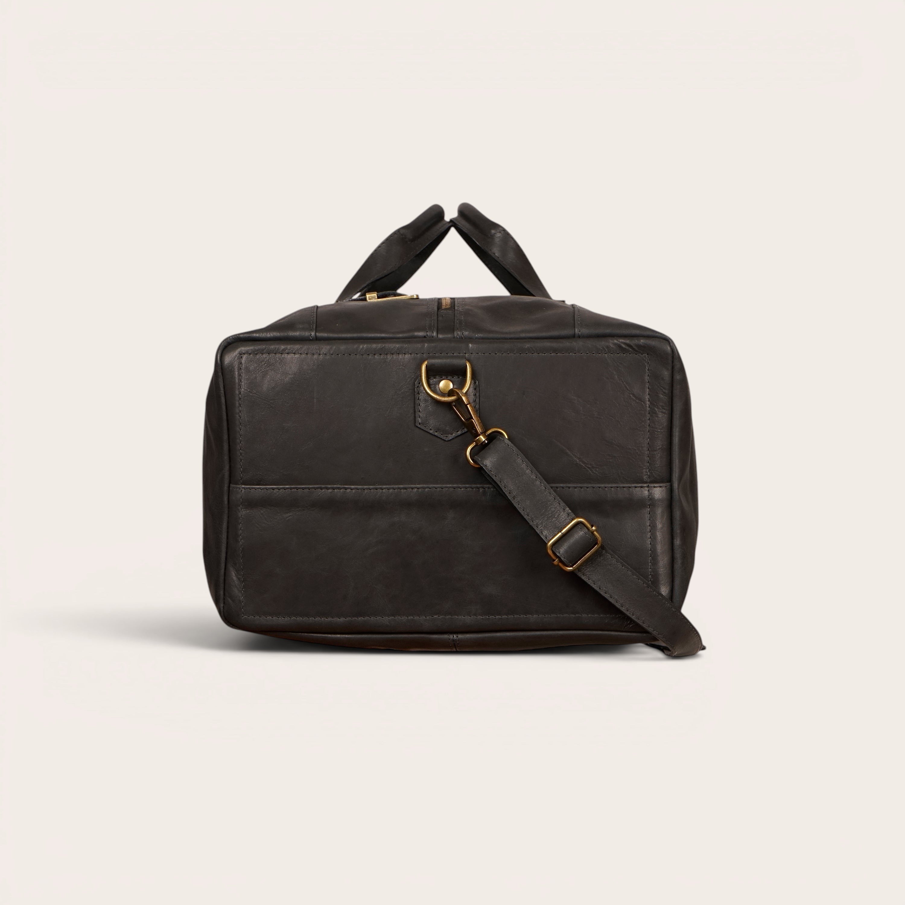 Bolso de viaje OLKI Yelcho negro de piel con asas superiores y correa de hombro extraíble.