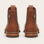 Botín Chelsea de cuero moka para hombre OLKI con suela de caucho chocolate y elásticos laterales. Detalle de lengüeta trasera.