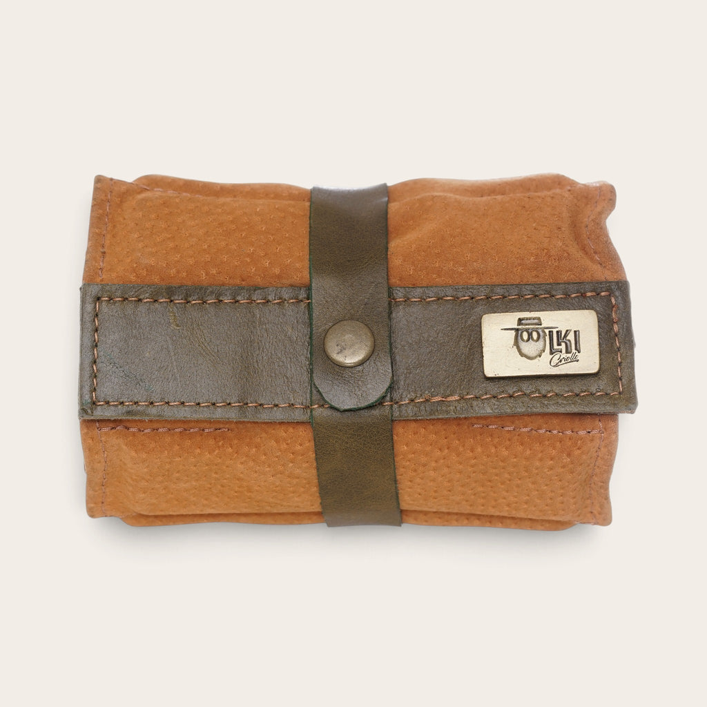Estuche enrollable para dominós OLKI de cuero natural color café con cierre de correa y placa metálica de la marca
