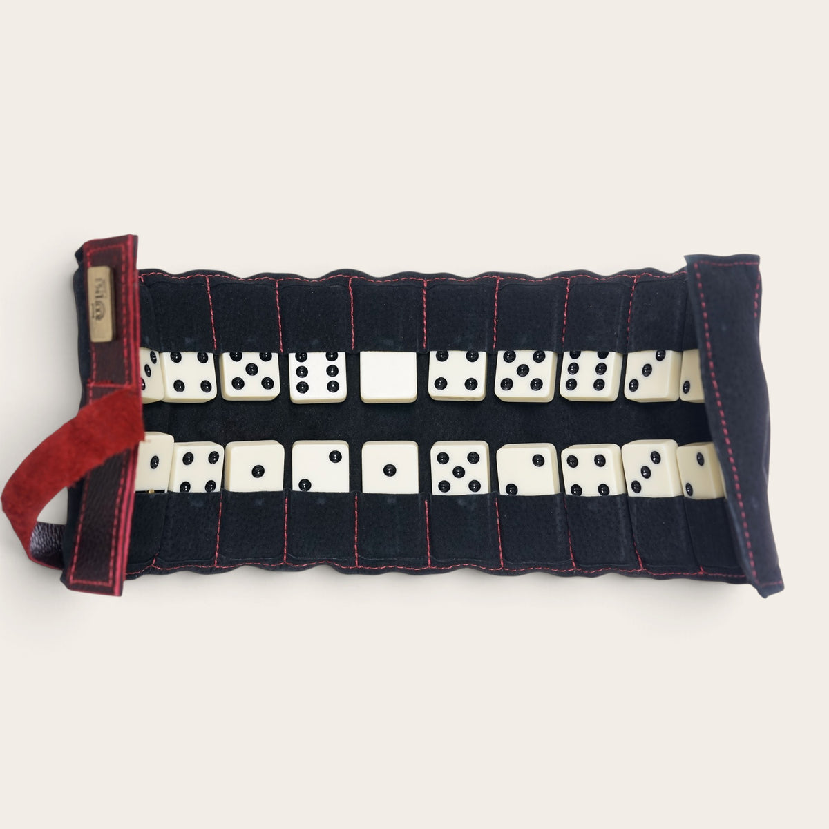 Estuche enrollable de cuero natural negro OLKI para dominó con compartimentos individuales y costuras en contraste.