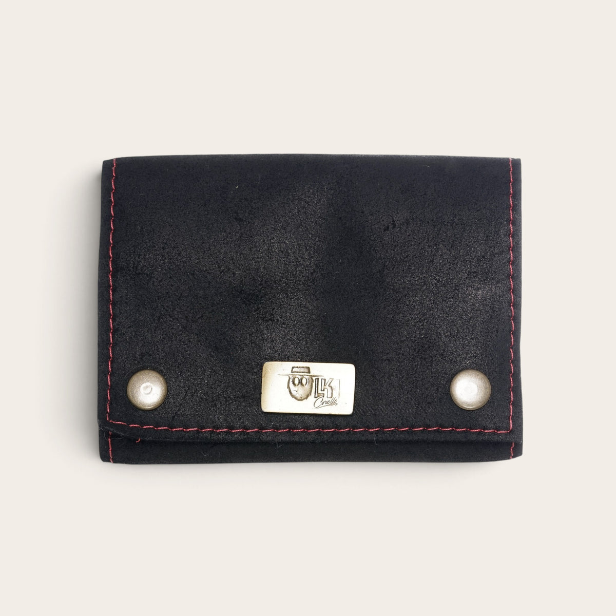 Estuche para naipes OLKI de cuero natural negro con costuras rojas y placa metálica frontal