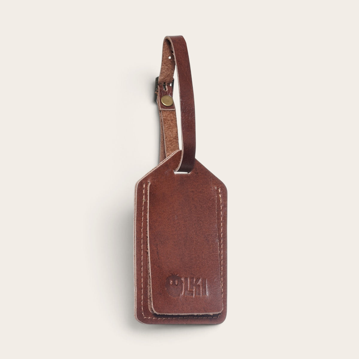 Identificador de equipaje OLKI Huasco en cuero natural color castaño con correa ajustable y logo grabado
