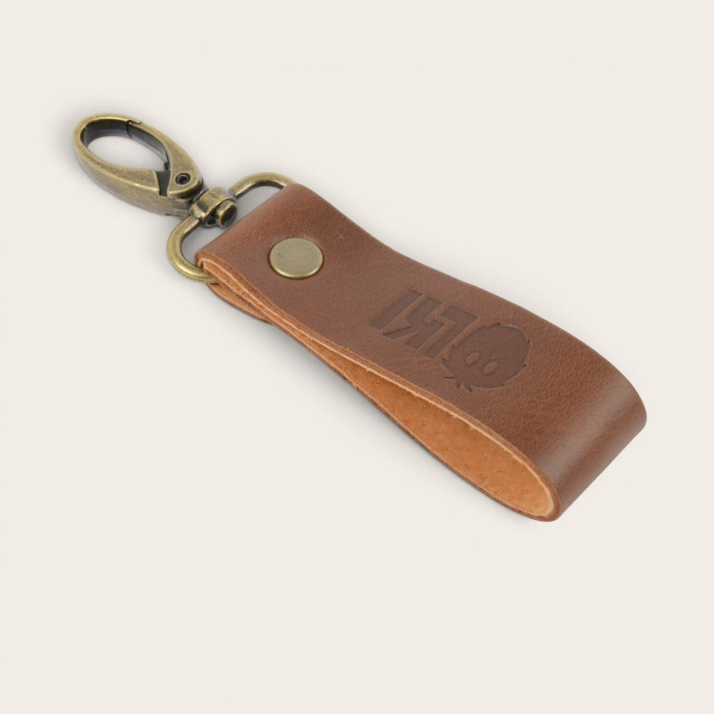 Llavero OLKI Huilo Huilo Habano de cuero marrón con grabado de logo y mosquetón metálico.