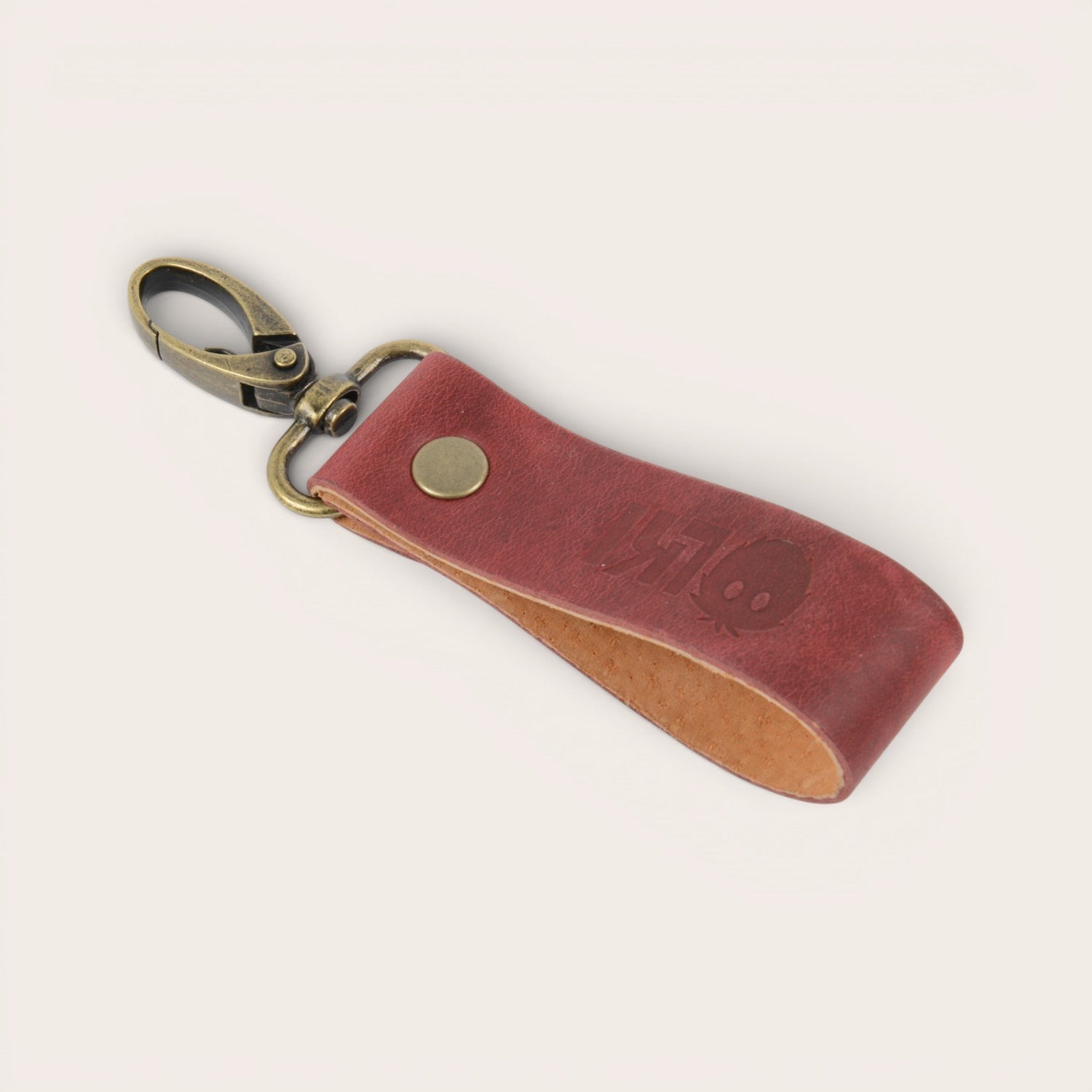 Llavero OLKI Huilo Huilo rojo de cuero de vacuno con mosquetón vintage y remache metálico.