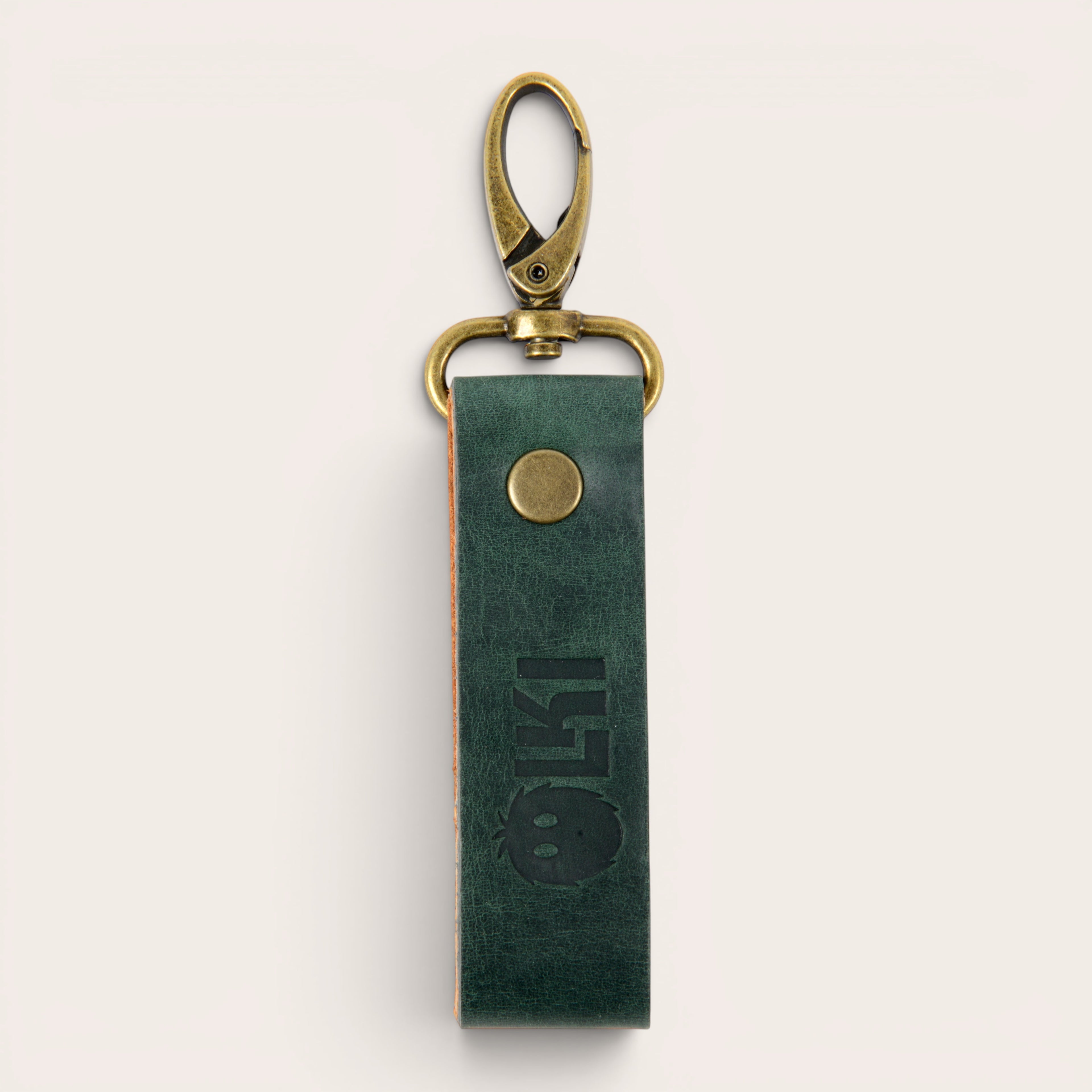 LLAVERO MOSQUETON OLKI de cuero verde con herrajes metalizados envejecidos y logo grabado.