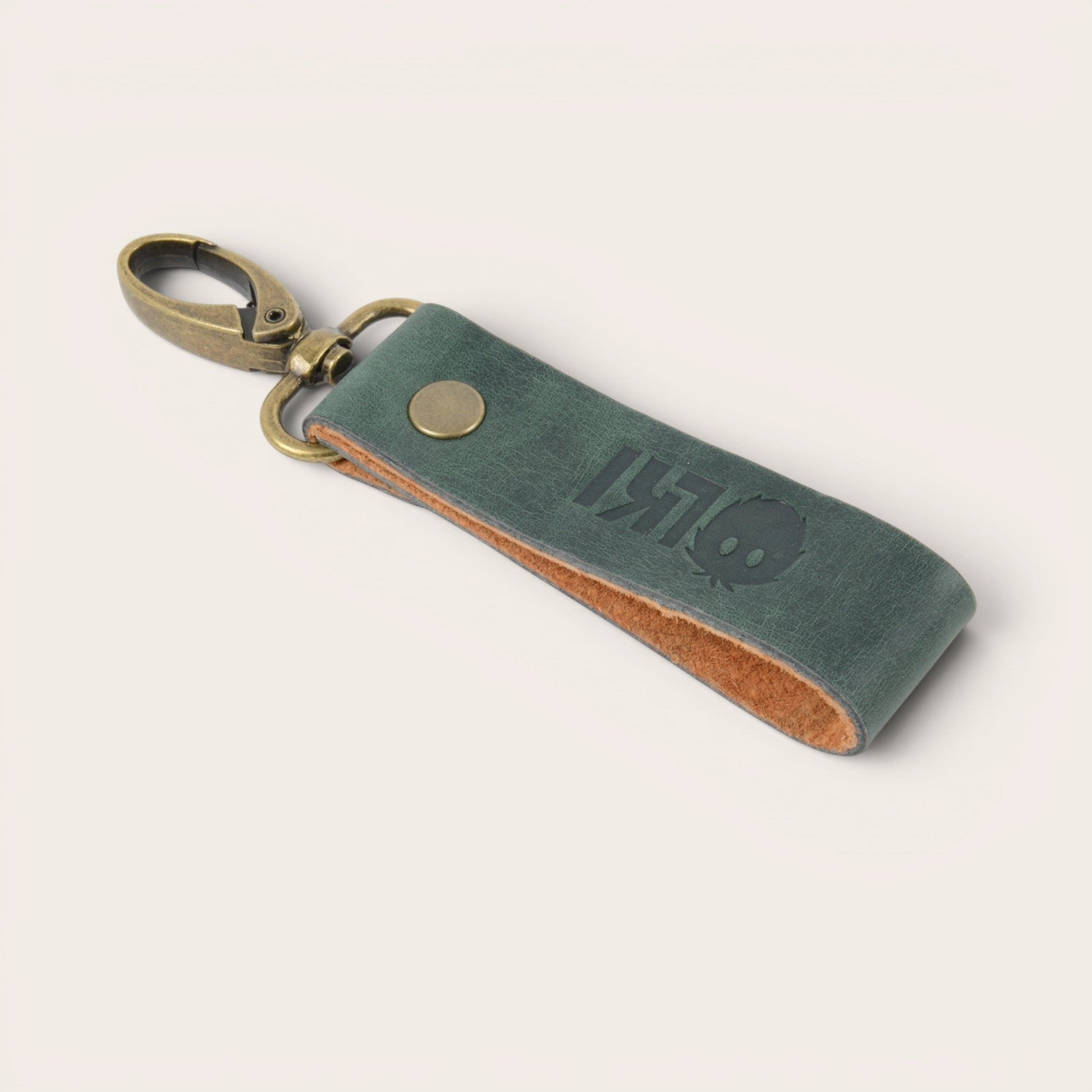 Llavero OLKI Huilo Huilo verde de cuero de vacuno con mosquetón y remache metálico. Diseño grabado.