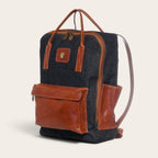 Mochila OLKI Caliboro de mezclilla gris con detalles en cuero café, diseño compacto y funcional para uso diario.