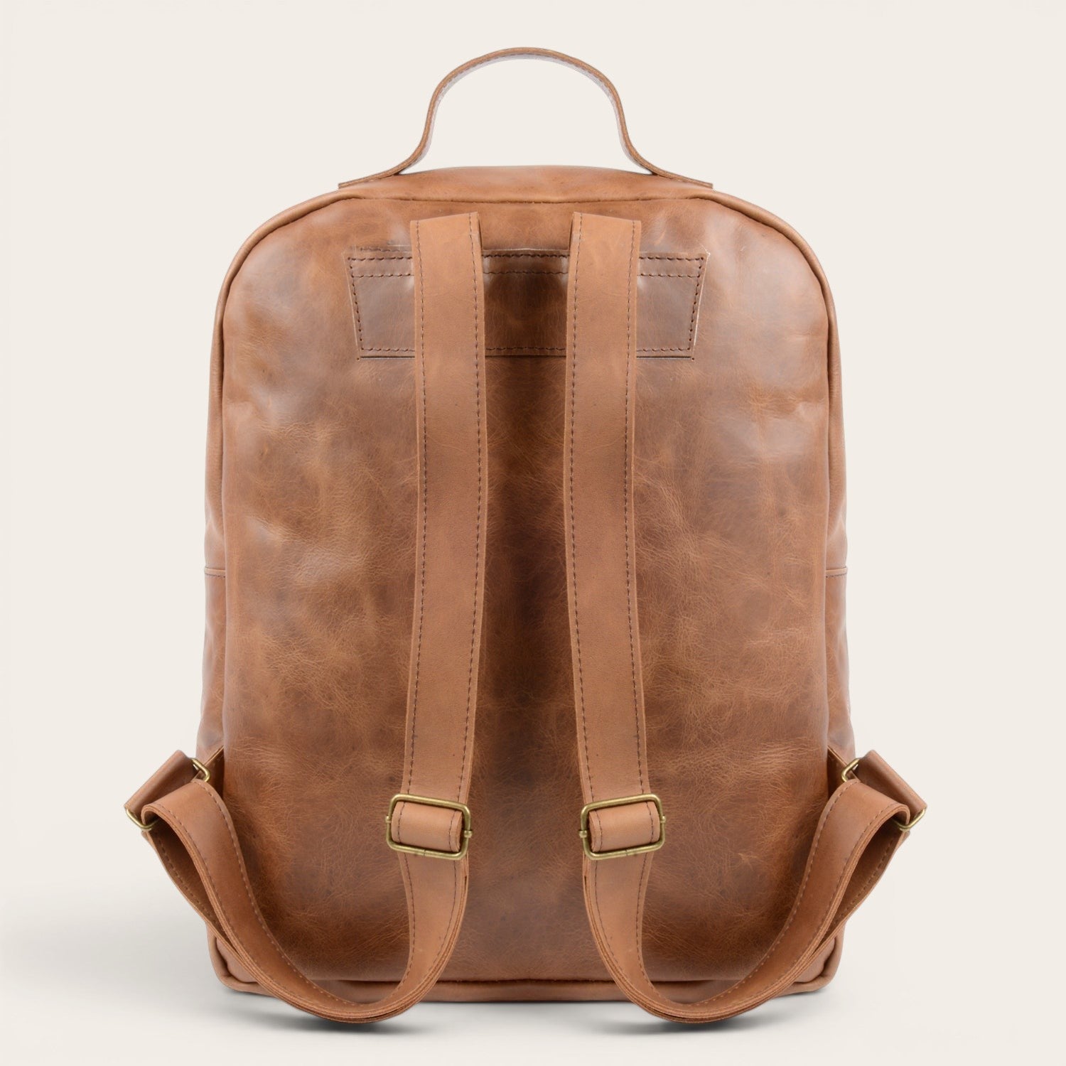Mochila OLKI Toltén de cuero vacuno en color habano, con tirantes ajustables y compartimento para portátil.