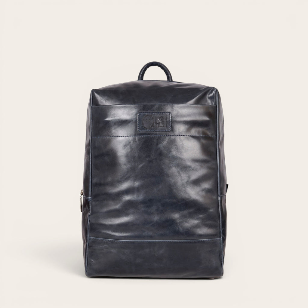 Mochila OLKI Imperial azul marino de cuero natural, con compartimento acolchado para portátil y 15 litros de capacidad.