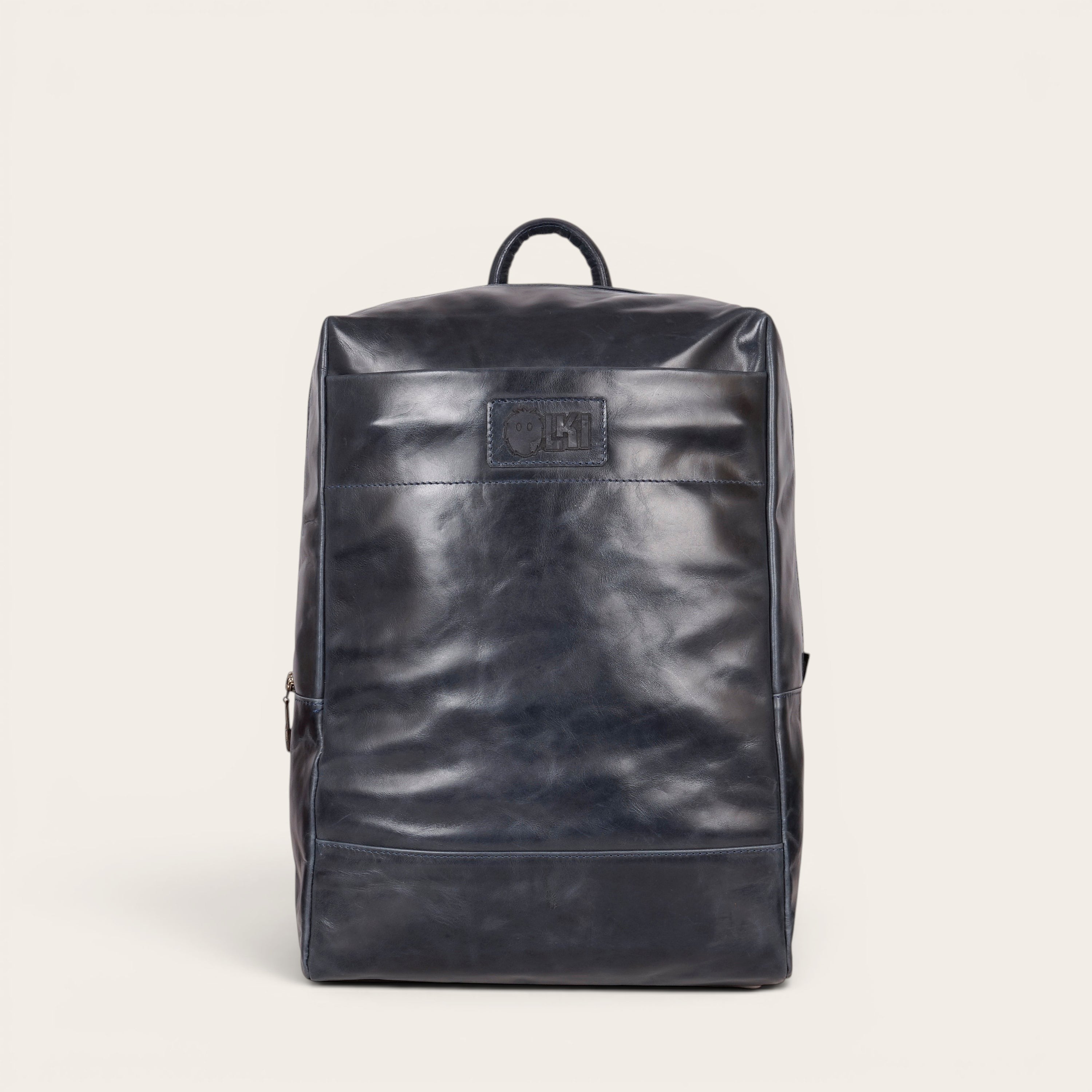 Mochila OLKI Imperial azul marino de cuero natural, con compartimento acolchado para portátil y 15 litros de capacidad.