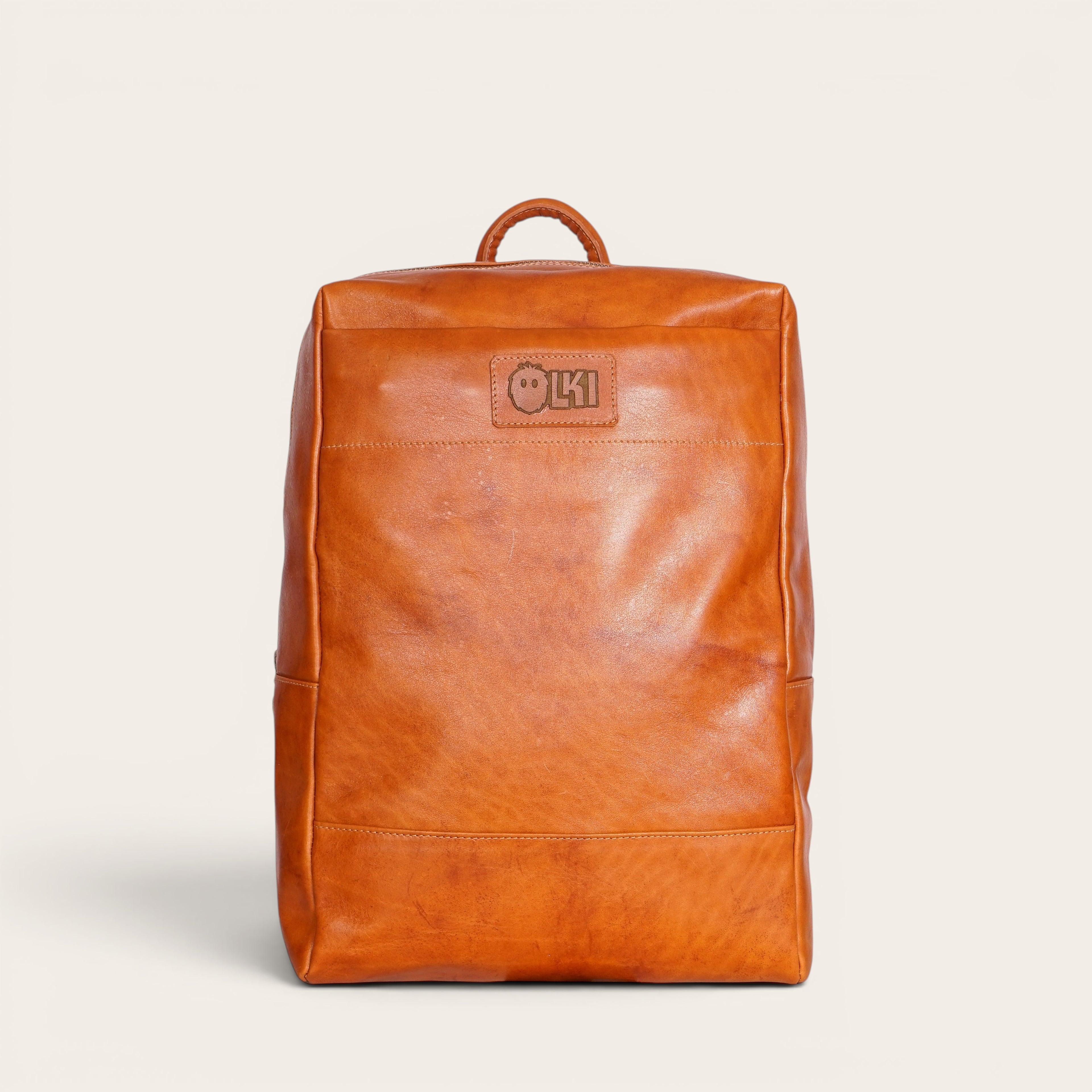 Mochila OLKI Imperial de cuero natural color coñac, con compartimento para portátil y 15 litros de capacidad.