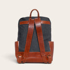 Mochila OLKI Imperial de mezclilla gris con detalles y correas de cuero marrón, vista trasera estructurada.
