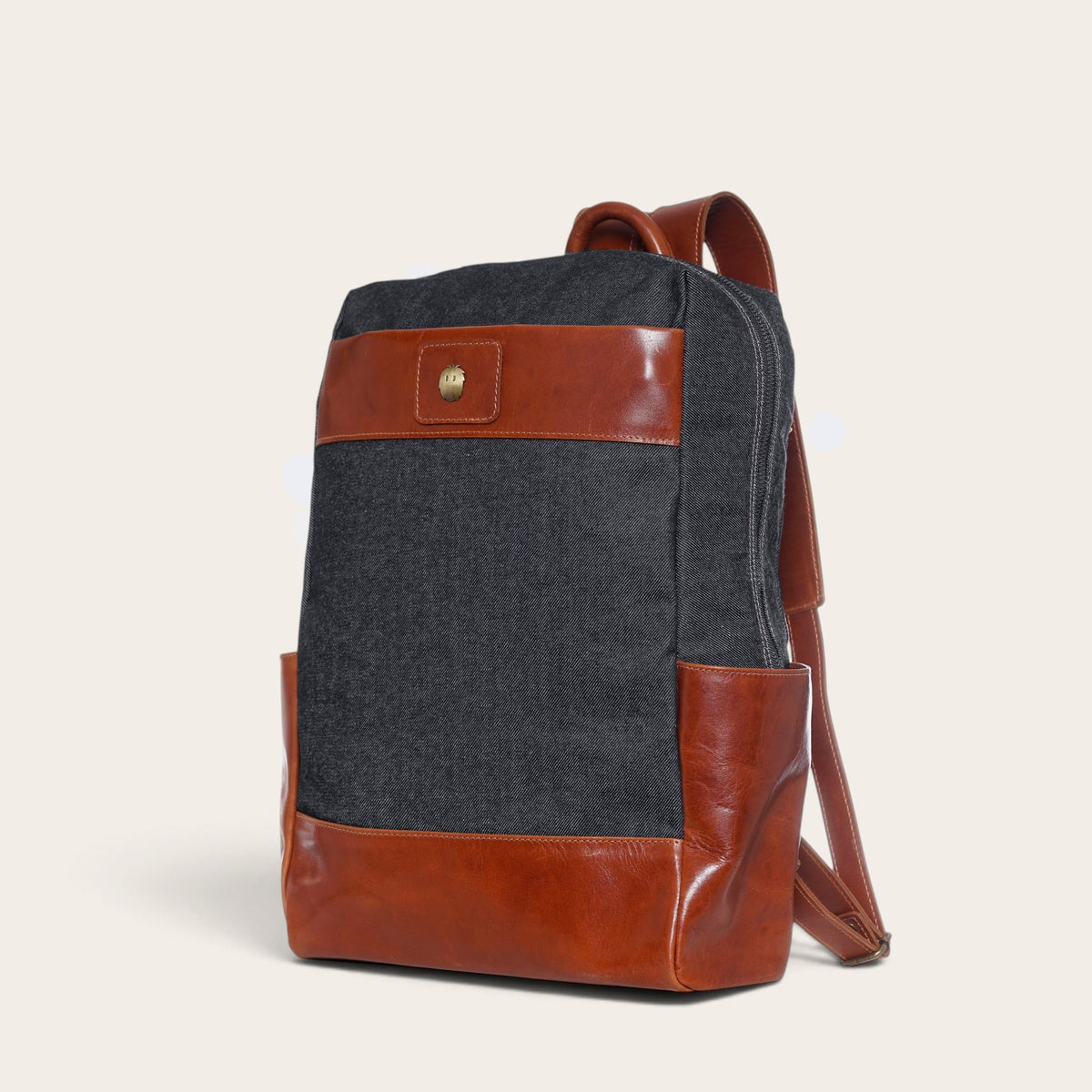 Mochila OLKI Imperial gris de mezclilla con detalles en cuero marrón, diseño estructurado y correas ajustables.