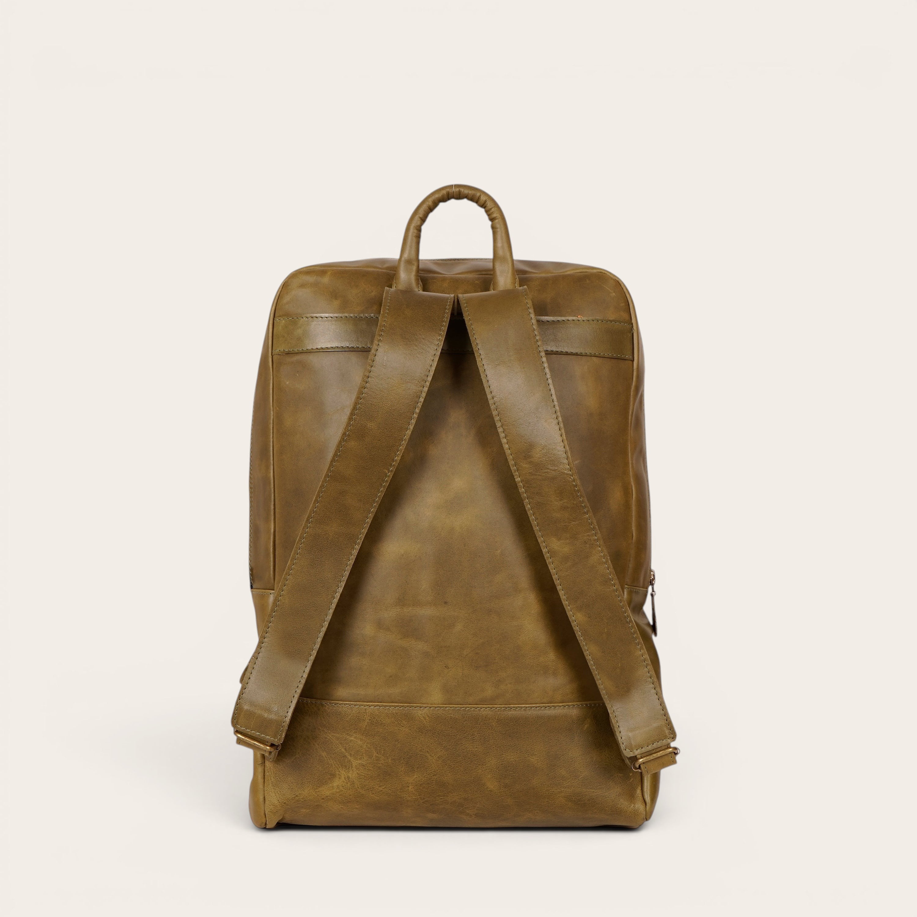 Mochila OLKI Imperial verde de cuero natural, con compartimento acolchado para portátil y 15 litros de capacidad.
