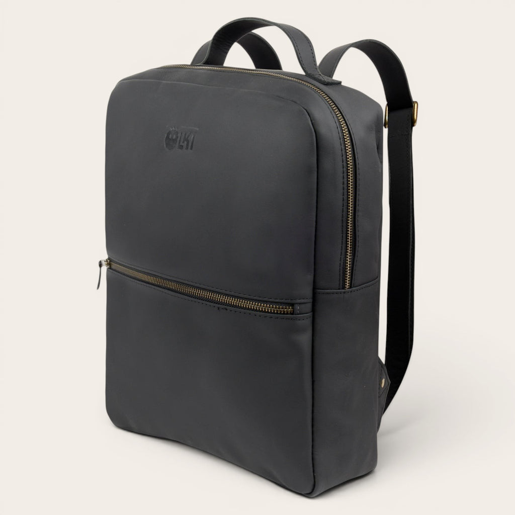 Mochila negra de cuero de vacuno OLKI Toltén con cremalleras doradas y logo grabado. Diseño minimalista.