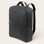 Mochila negra de cuero de vacuno OLKI Toltén con cremalleras doradas y logo grabado. Diseño minimalista.