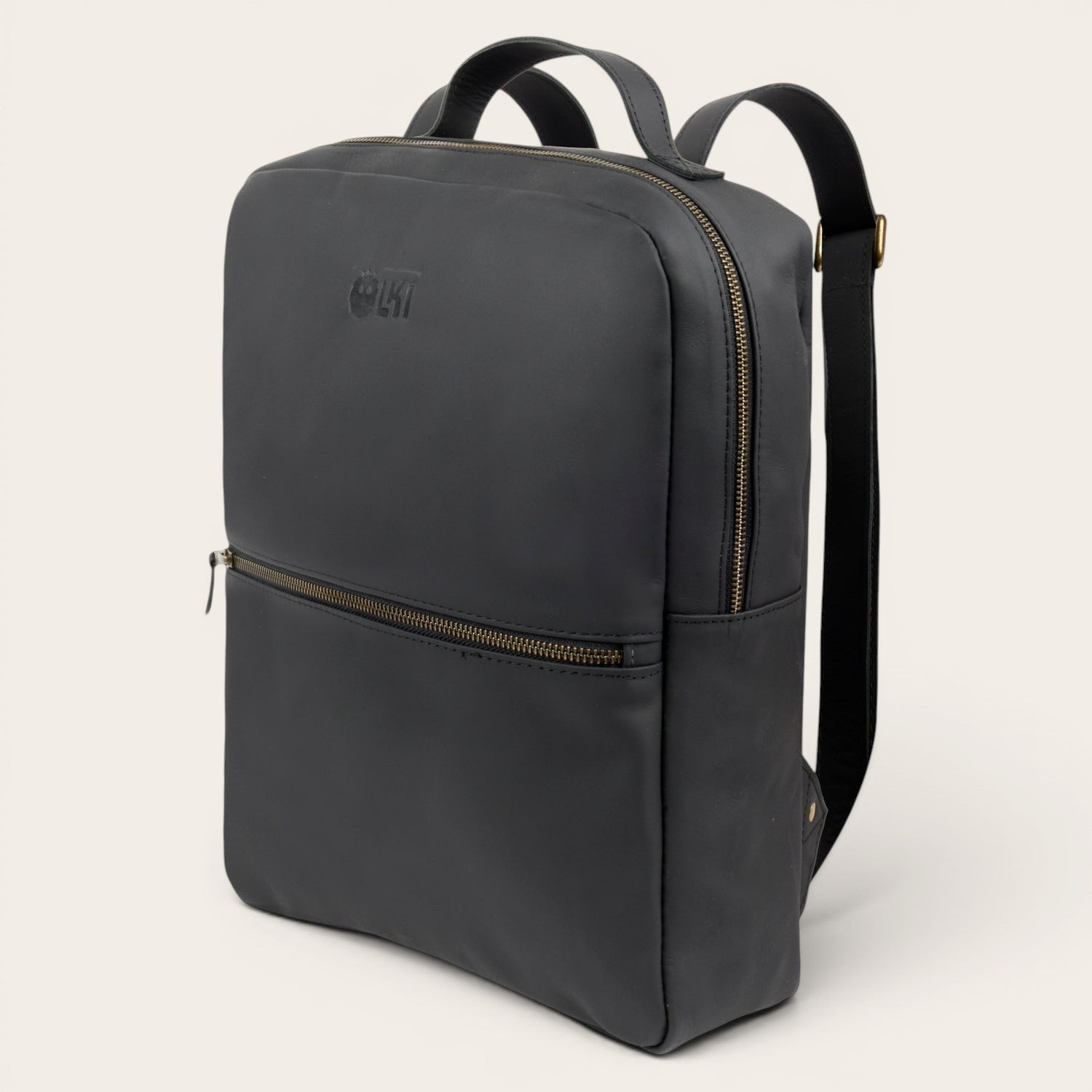 Mochila negra de cuero de vacuno OLKI Toltén con cremalleras doradas y logo grabado. Diseño minimalista.