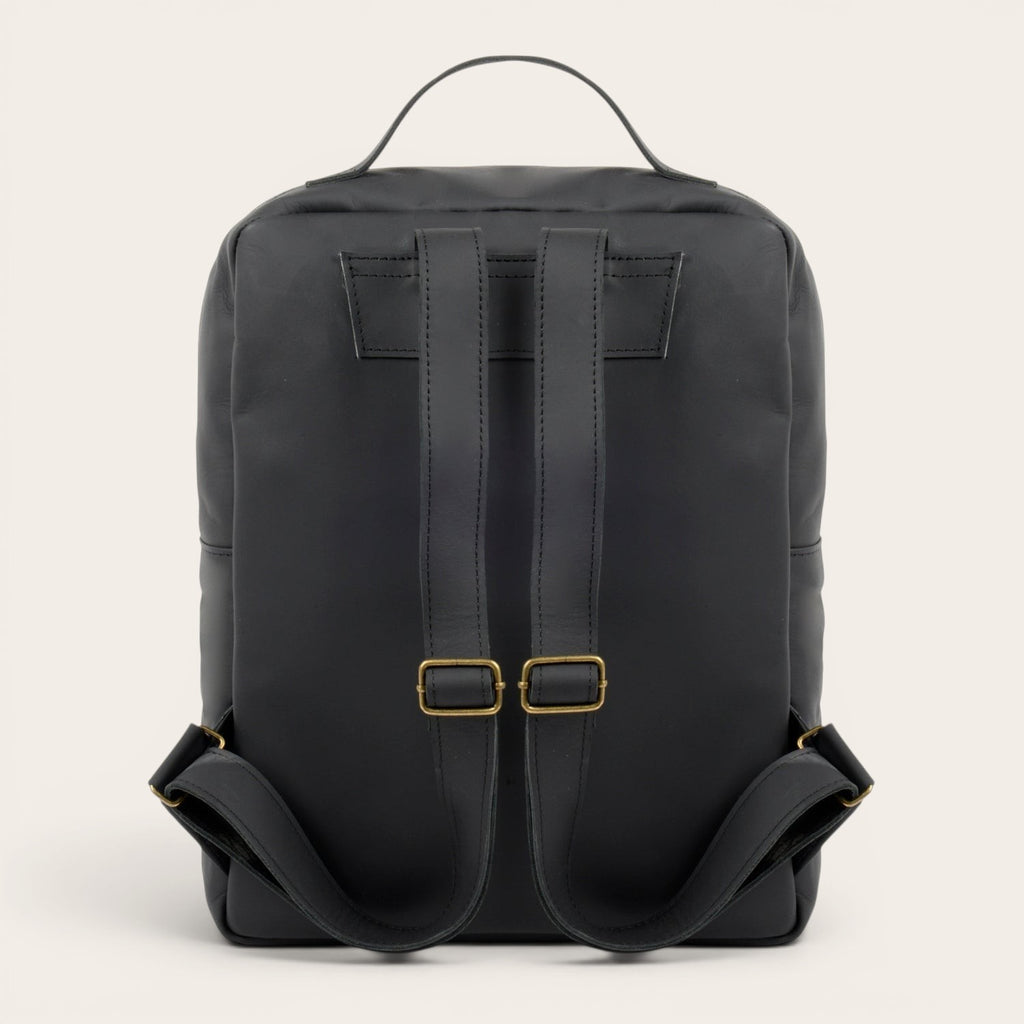 Mochila negra de cuero de vacuno OLKI Toltén con correas ajustables y compartimento para portátil. Diseño minimalista.