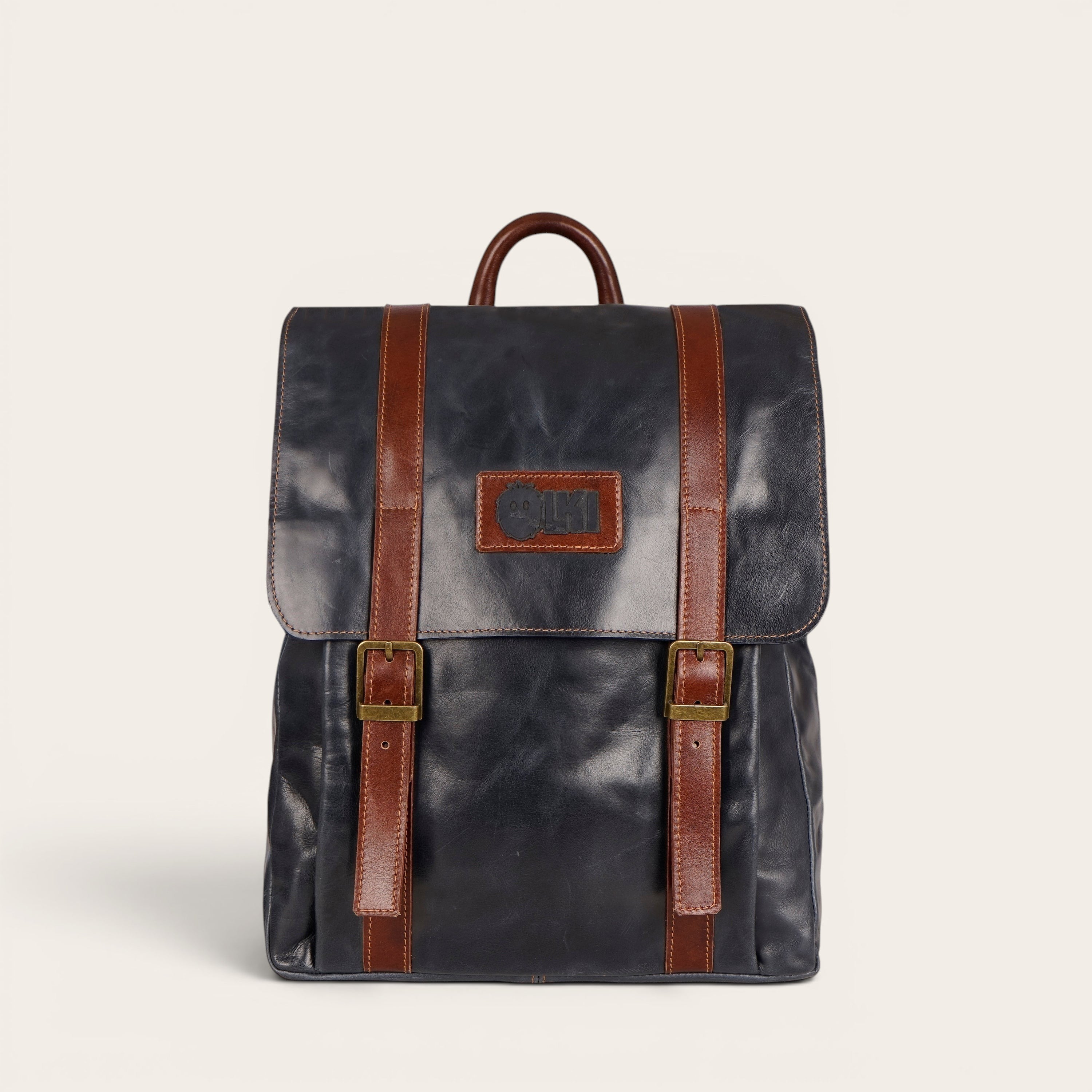 Mochila Trancura Azul de cuero de vacuno de OLKI con correas y hebillas de cuero marrón.
