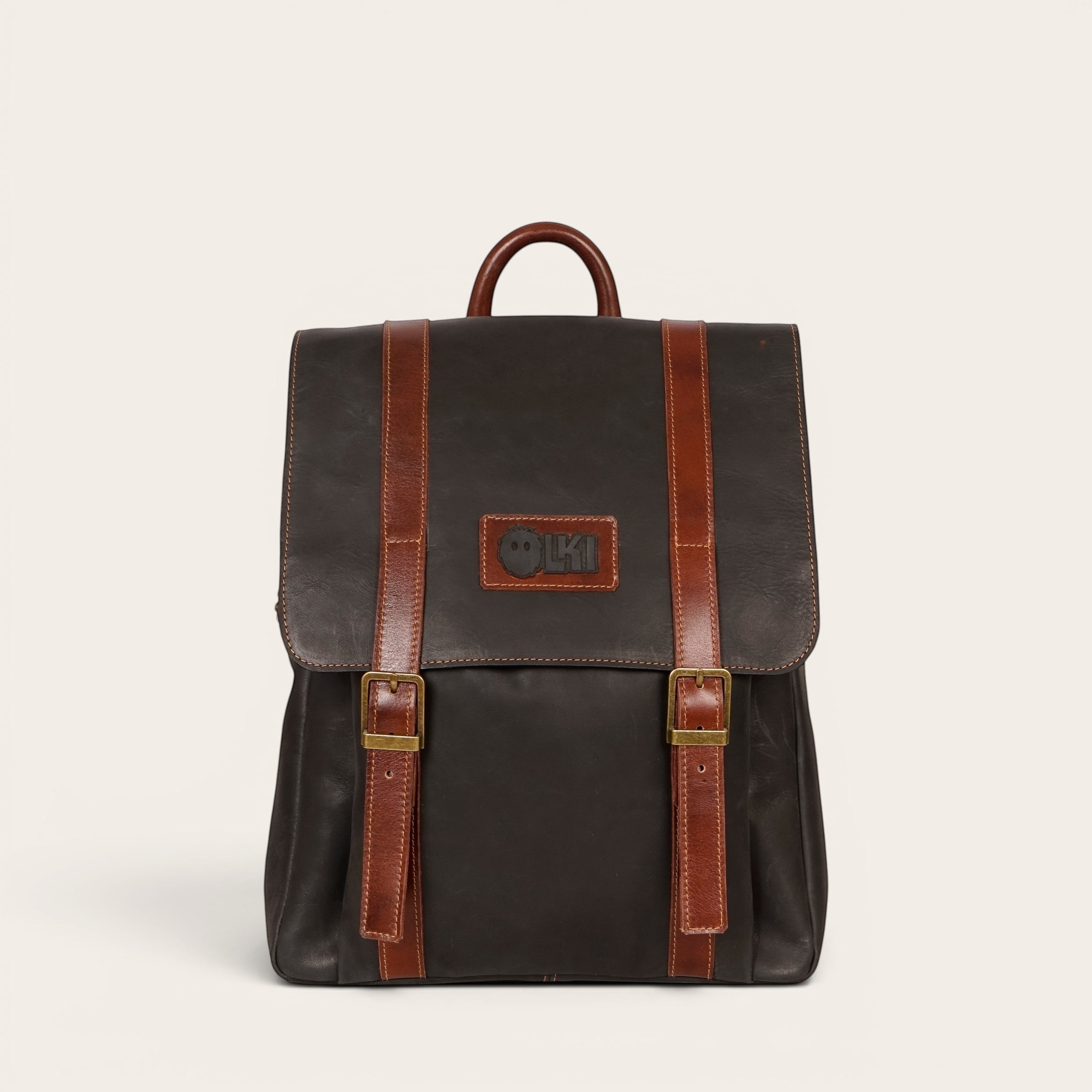 Mochila Trancura Negra de cuero de OLKI con correas de cuero marrón y hebillas doradas. Diseño clásico.
